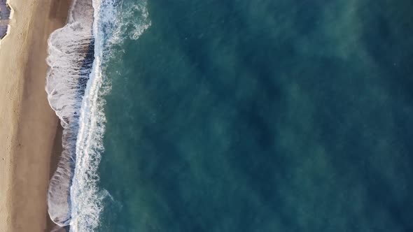 Bird View of Ocean Waves Crashing Into Sandy Beach