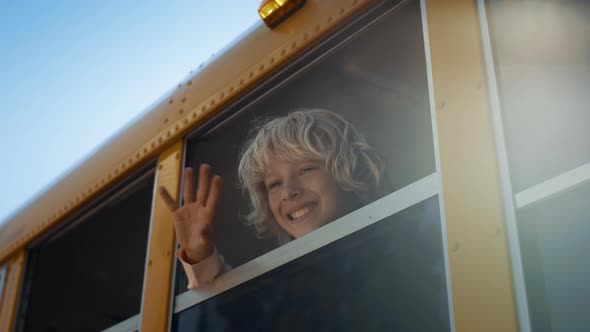 School Child Waving Out School Bus Window Closeup