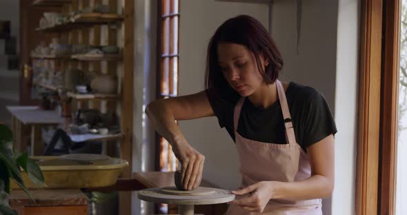 Young female potter working in her studio