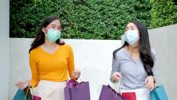 Asian woman wearing face mask. Happy woman with shopping bags