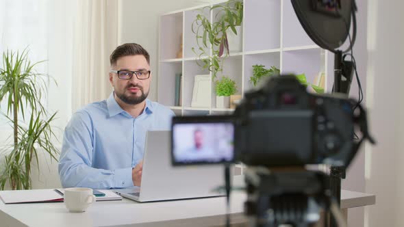 A male blogger is recording a video on a camera. Vlog concept.