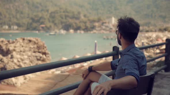 Guy In Sunglasses Sitting On Bench And Thinking.  man Sitting On Bench Near Sea.