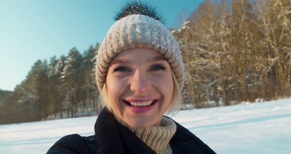 Young Cheerful Girl Taking Selfie in Winter Forest at Ski Resort
