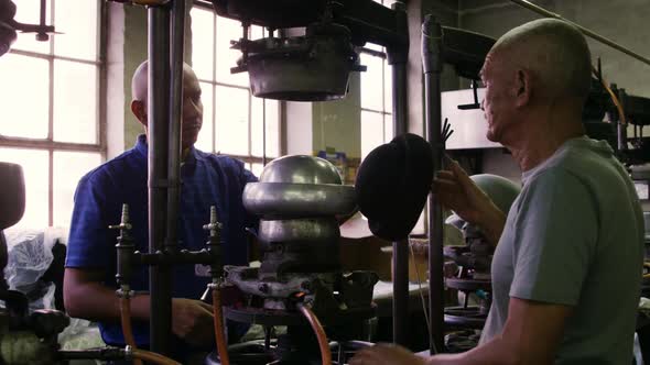 Mixed race men working at a hat factory