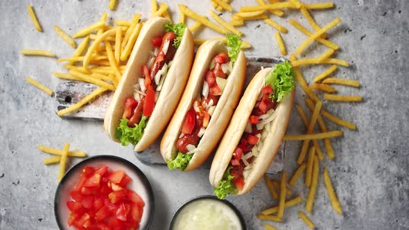 Assortment of Three Tasety Hot Dogs, Placed on Wooden Cutting Board