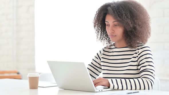 African Woman with Laptop Looking at Camera