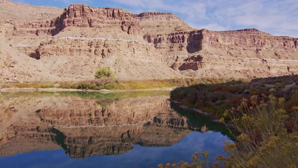 Reflection of desert cliffs in the glassy water of the Green River