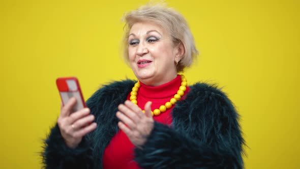 Charming Senior Woman Using Video Chat on Smartphone Smiling