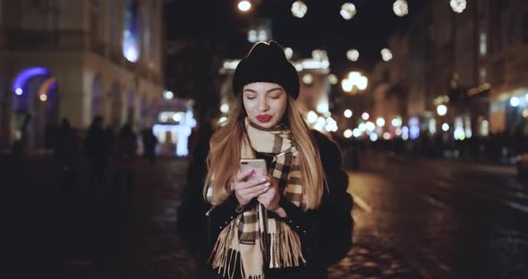 Woman Using SmartPhone at Night in City