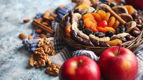 Composition of Dried Fruits and Nuts in Small Wicker Bowl Placed on Stone Table