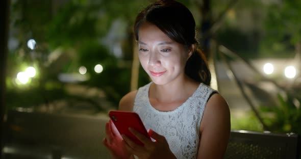 Woman use of mobile phone at outdoor in the evening