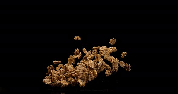 Walnut Kernels, juglans regia, Fruits falling against Black Background, Slow Motion 4K