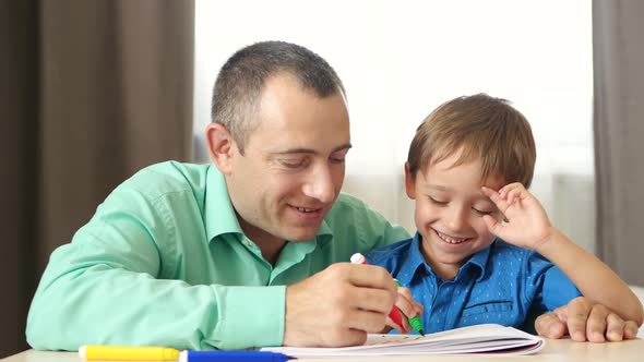 Happy Family: Father and Son Spend Time Painting with Colored Markers