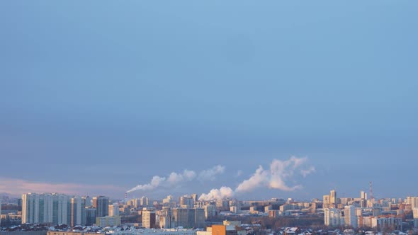 City Pipes Emit Steam Into the Atmosphere Against the City Skyline