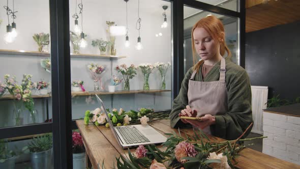 Florist Using Smartphone At Work