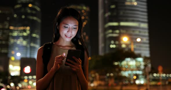 Woman using smart phone in Hong Kong at night 