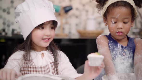 Group of children baking cake together in classroom, Multi-ethnic young boys and girls happy making.