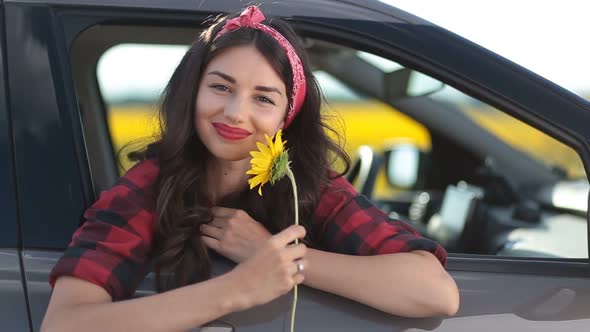 Carefree Woman Smelling Sunflower on Roadtrip