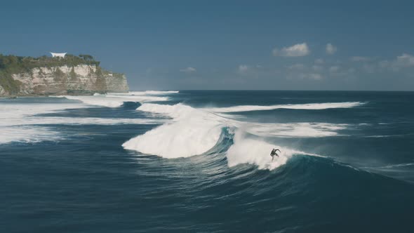 Surfer Rides the Big Waves at Blue Point Beach, Indian Ocean in Uluwatu, Bali, Indonesia, Aerial
