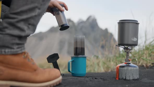 Man Preparing Coffee On Black Sand