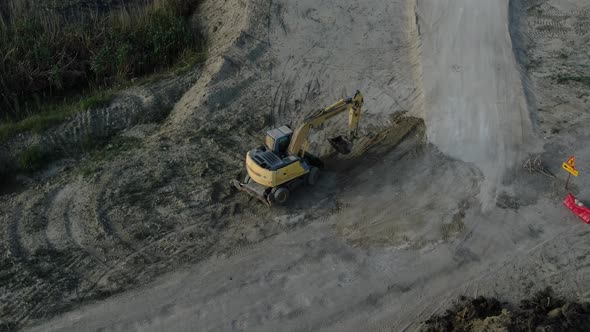 An Excavator is Building an Earthen Road