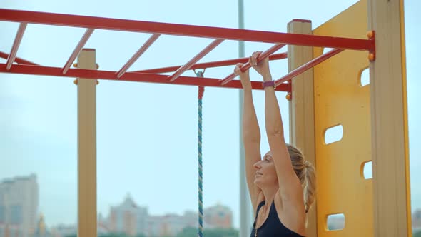Fitness Sport Street Workout. Muscle Up In Public Gym. Healthy Woman On Pull-up Bars Exercising.