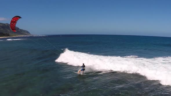 Aerial view of a man kitesurfing in Hawaii.