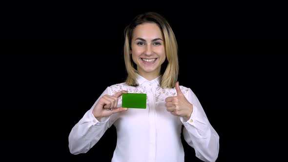 Young Businesswoman in a White Shirt Holds a Bank Card in Hand and Shows Like