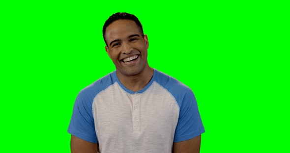 Smiling man standing against green screen