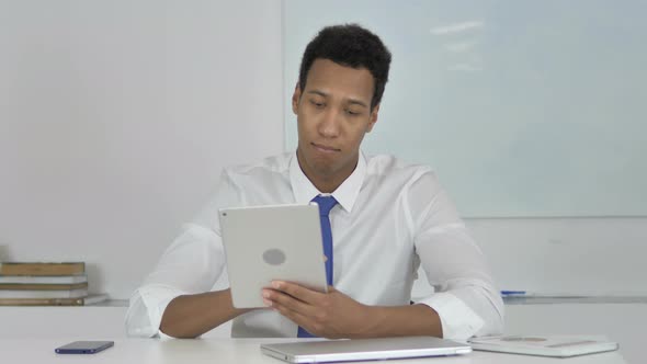 Afro-American Businessman Browsing Internet on Tablet