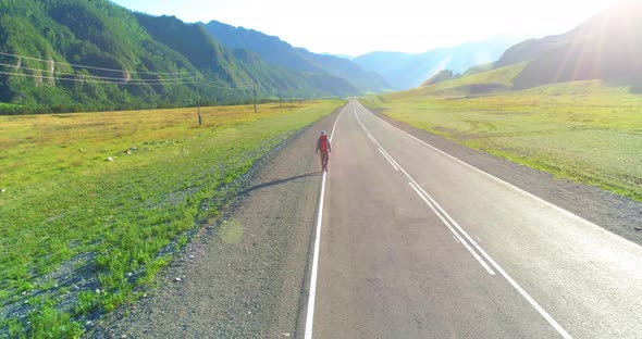 Flight Over Hitchhiker Tourist Walking on Asphalt Road