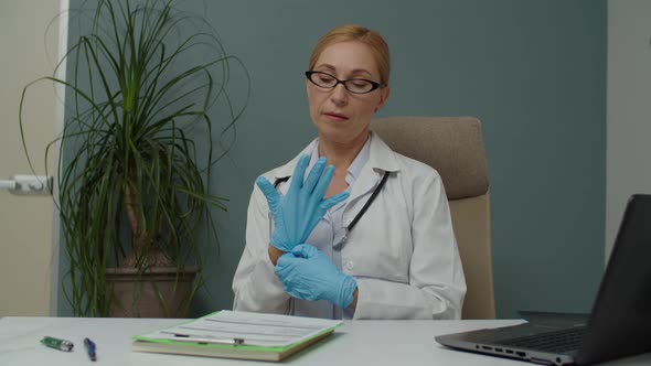 Female Doctor Preparing for Procedure Applying Latex Gloves Indoors