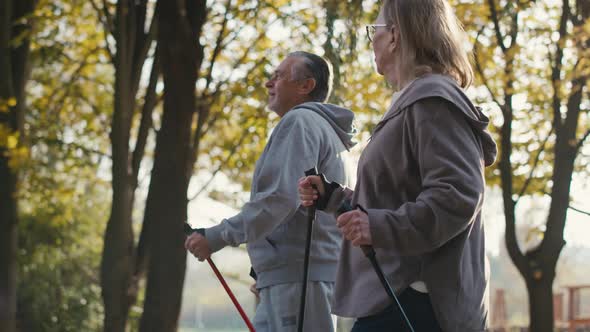 Caucasian senior couple nordic walking in the park. Shot with RED helium camera in 4K