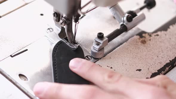 The Craftsman Stitches a Men's Leather Belt on a Sewing Machine