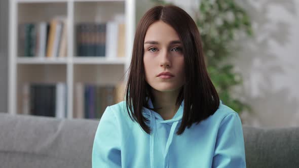 Woman Sitting on Couch with Sad Facial Expression