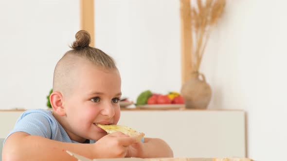 Happy Family Eating Delicious Pizza Sitting in the Kitchen at the Table