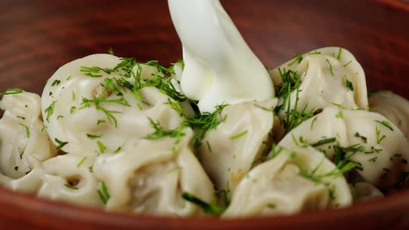 Adding Sour Cream Into Boiled Dumplings on Board Closeup Cooking Dough Products with Meat