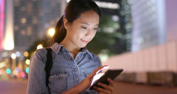 Asian woman use of mobile phone in the city at night 