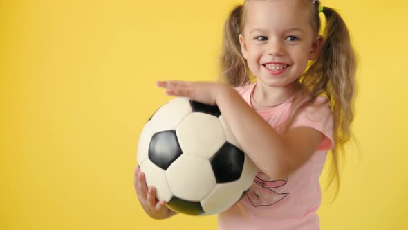 Authentic Cute Smiling Preschool Little Girl with Classic Black and White Soccer Ball Look at Camera