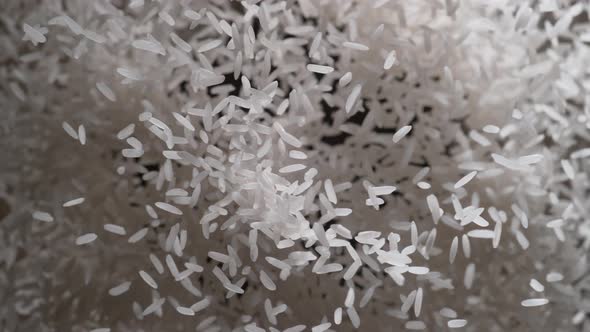 Rice flies after being exploded against black background. Slow Motion.