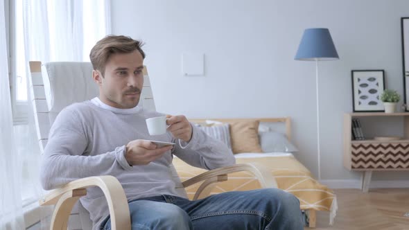 Relaxing Adult Man Drinking Coffee While Sitting on Casual Chair