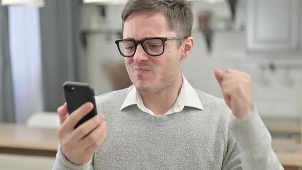 Young Man Reacting to Loss on Smartphone