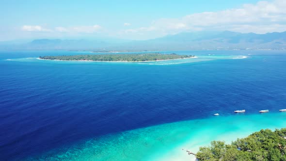 Aerial above scenery of perfect shore beach break by turquoise ocean and white sandy background of a