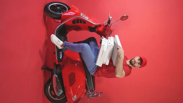 Studio Shooting of a Courier Delivery of Food Pizza To Take Away on a Scooter Chelevek Throws a