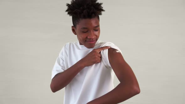 African American Teenager Showing COVID19 Vaccine Bandage Merrily