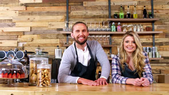 Portrait of waiter and waitresses standing at counter