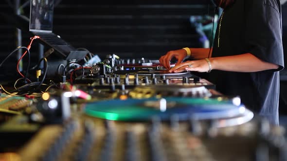 Professional dj woman plays musical tracks on analog turn table with vinyl records