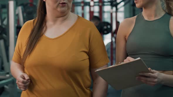 Close up of overweight woman talking with female trainer in the gym. Shot with RED helium camera in