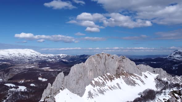 Aerial drone view of difficult access mountain peak for climbers during a winter sunny day