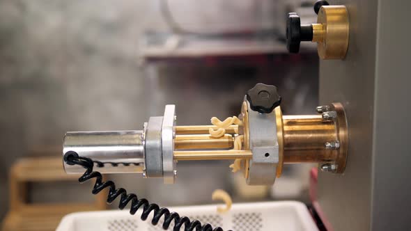 Tortiglioni Cazarece Spaghetti Pasta Falling From a Spout As They Travel Along the Production Line